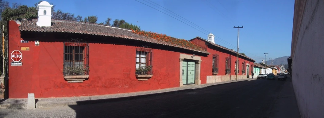 a small red brick street with green and tan buildings