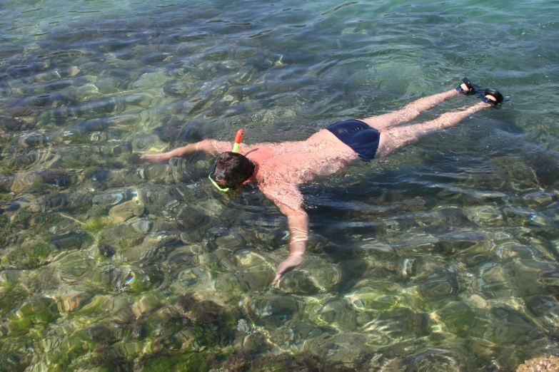 a person floating in the water and holding a flip flop