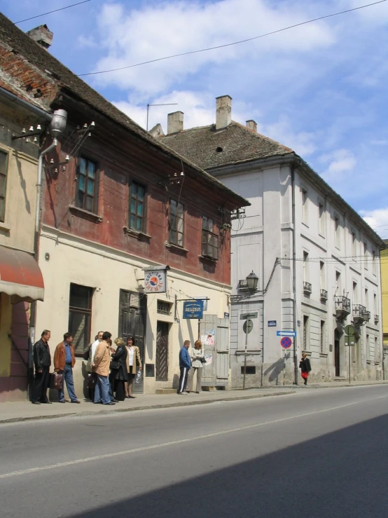 some people on the side walk with many buildings