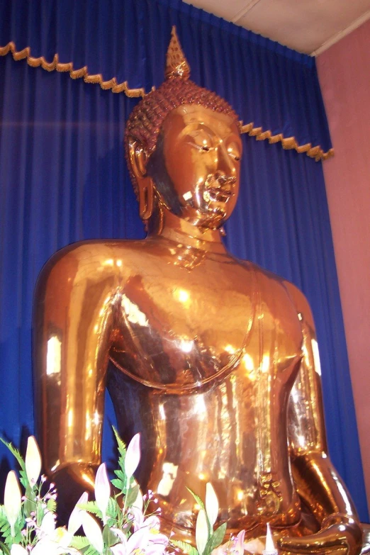 a large gold buddha statue sitting on top of a desk