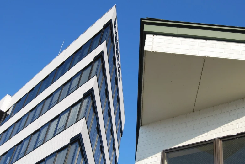 two buildings with black and white detailing against a blue sky