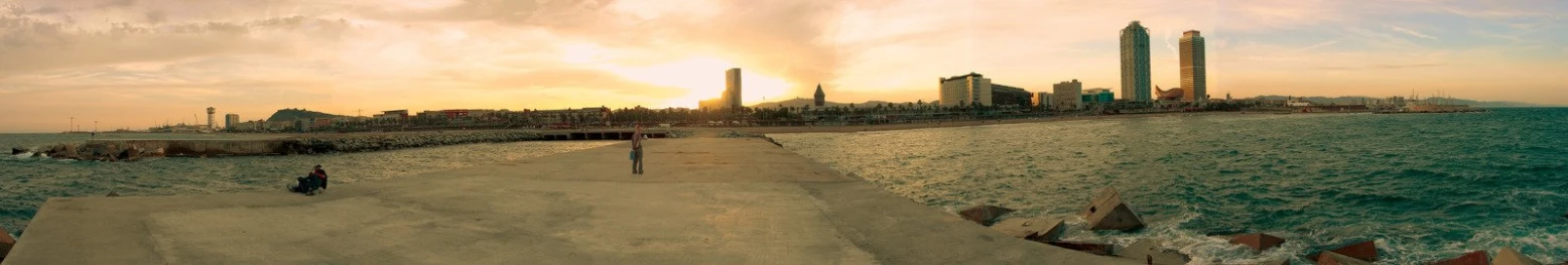 a man is looking at his skateboard at a pier