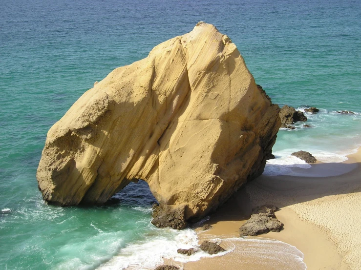 a large rock shaped like an animal is in the middle of the ocean