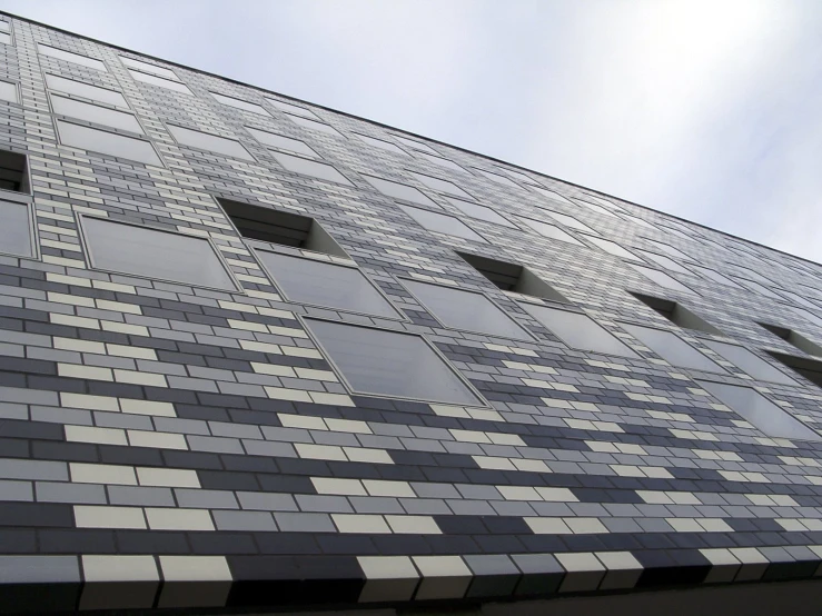 a tall building with many windows near a street