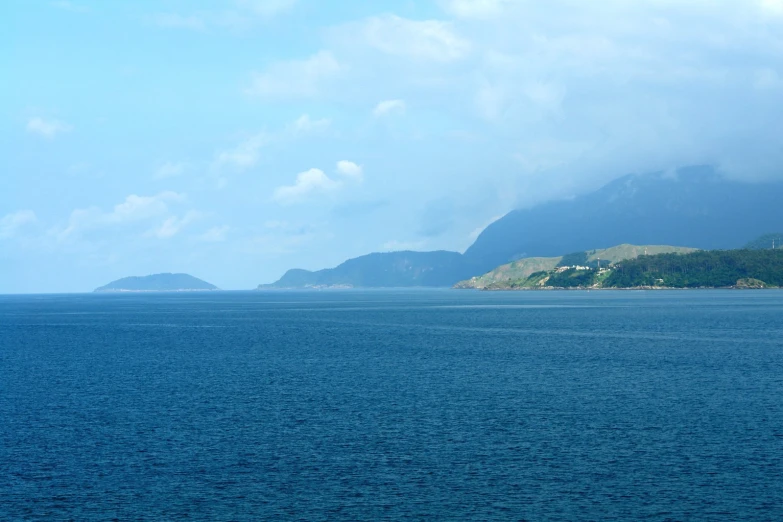 a body of water that has some hills in the background