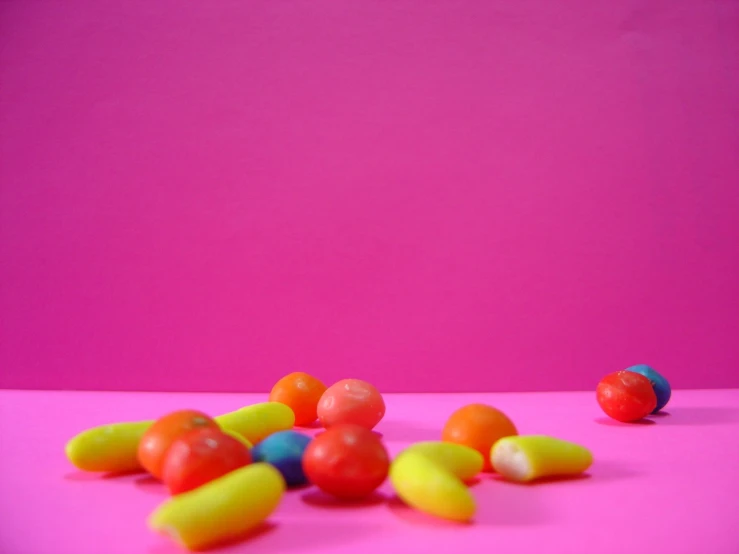 colorful candies scattered on a bright pink background