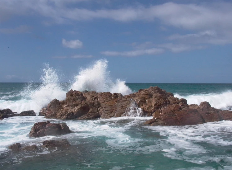 an ocean with rough waves crashing against the rocks