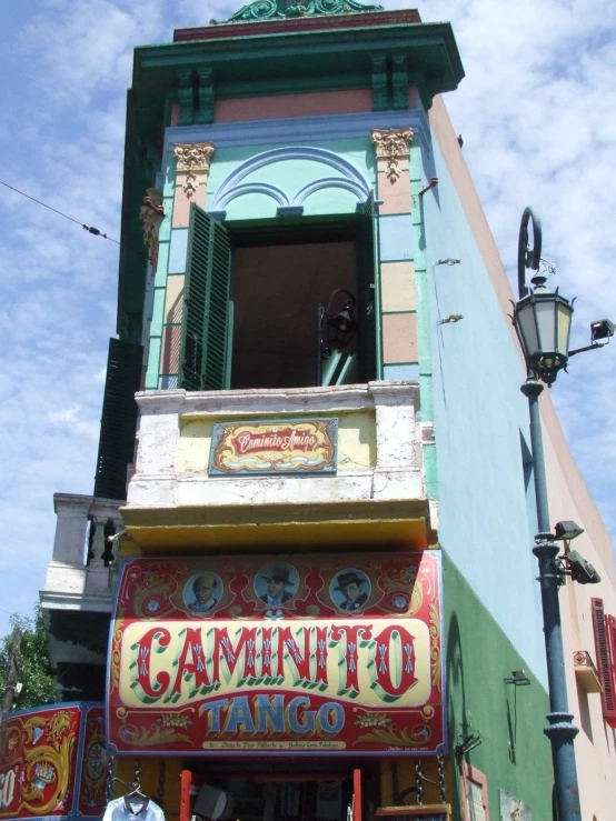 a man sits at the top of a building with many colorful signs