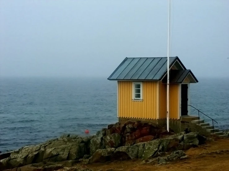 small building standing at the shore on an overcast day