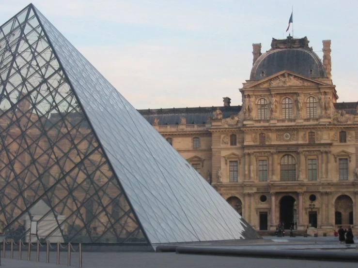 a large glass building with a pyramid in front