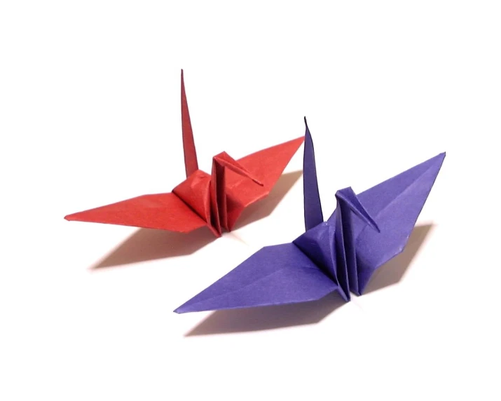 two origami cranes sitting next to each other