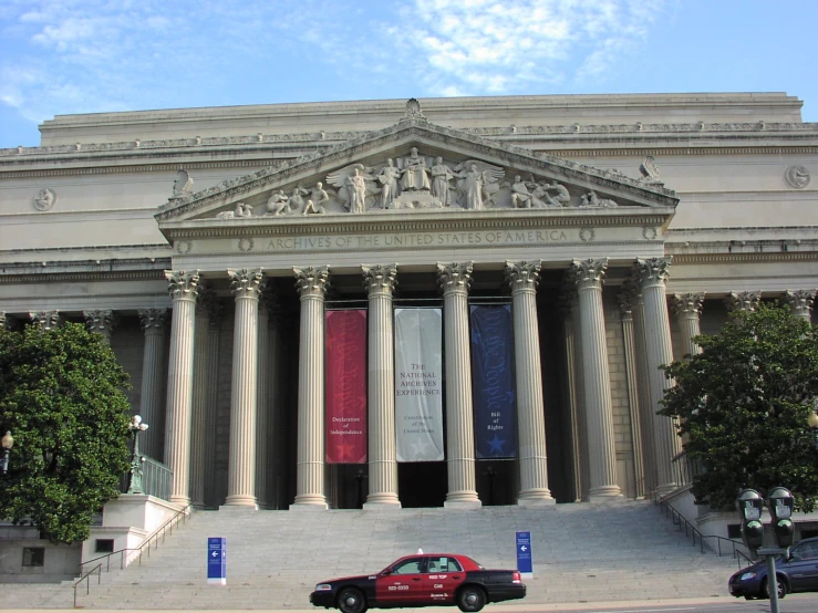 the red car is parked in front of the building