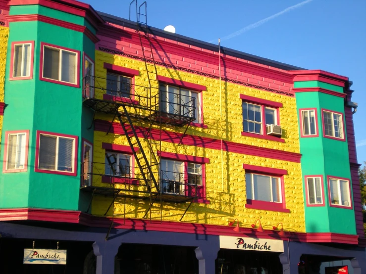 a building with multiple windows and balconies is painted rainbow
