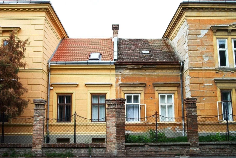 some very tall yellow buildings and a black fence