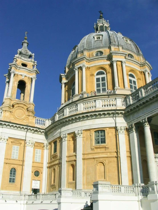 a large round building with two steeples under a blue sky