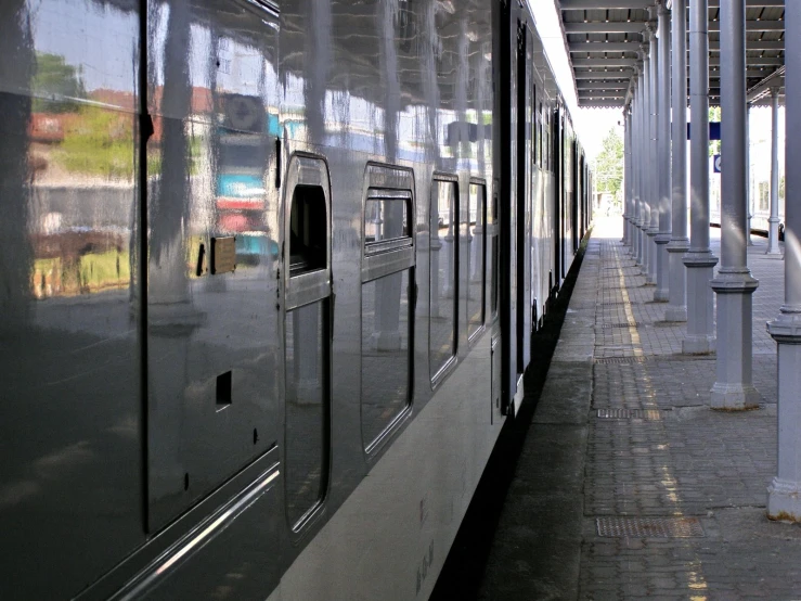 a passenger train traveling down tracks next to another vehicle