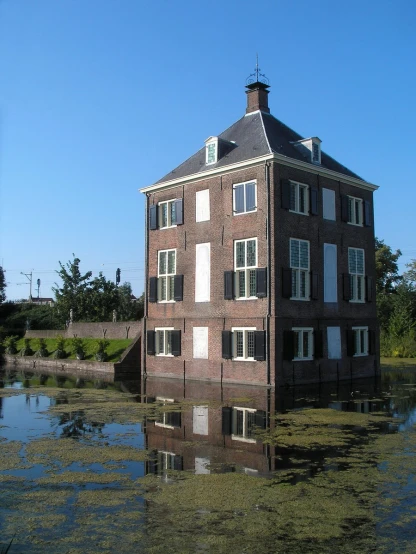 a large brown brick building next to a body of water