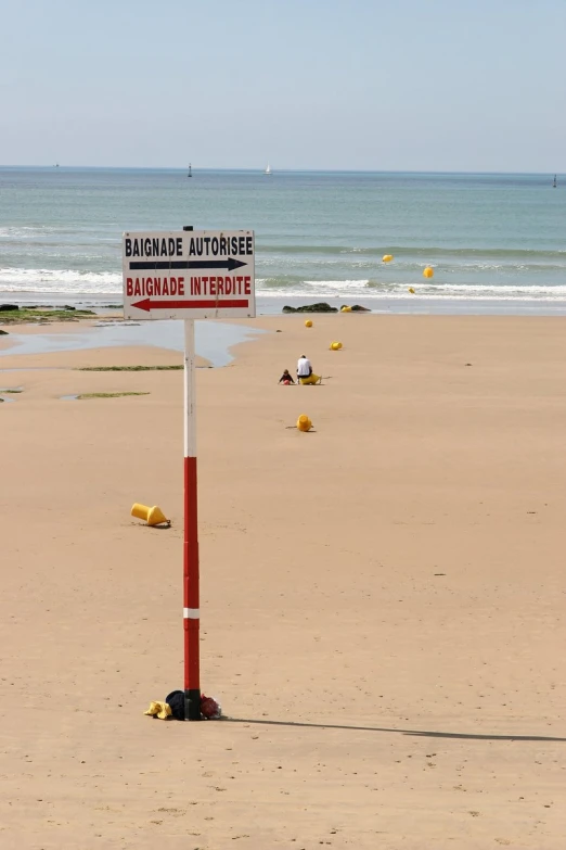 sign on red and white pole with sign stating caution,