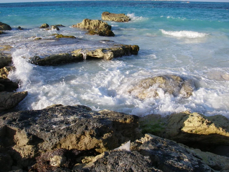 rocks that have water all over them and waves coming in