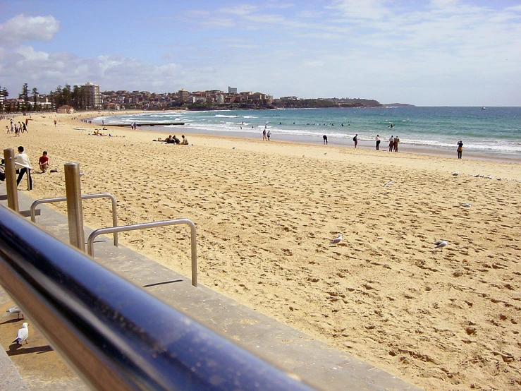 a beach with people walking along the sand