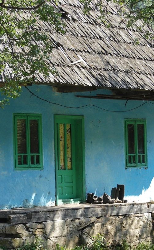 two green doors in front of a blue hut