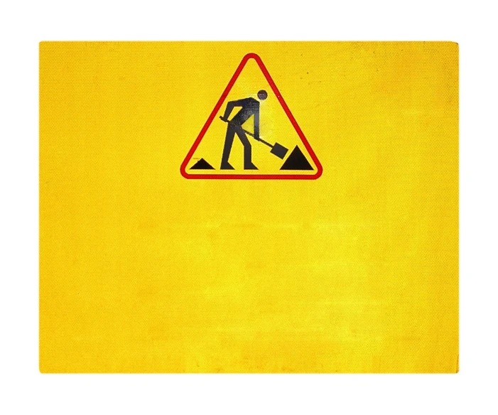 there is a warning sign that depicts a man with a shovel on the road