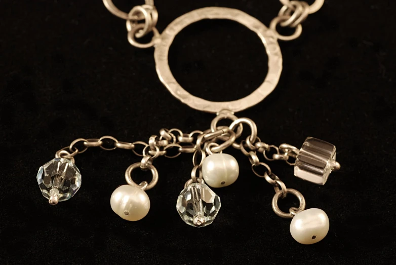 two small pearls hanging from the handles of a silver keychain