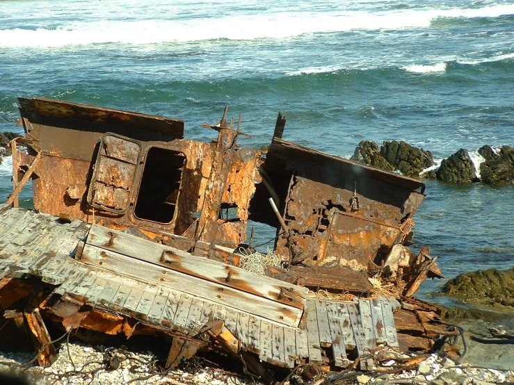 an old rusty boat sitting on top of a beach