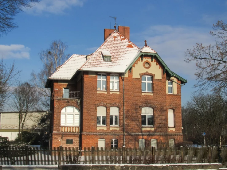 a brick house with white windows sitting in the snow