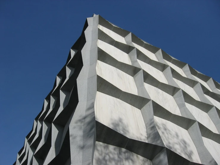 a concrete sculpture has wavy gray black lines