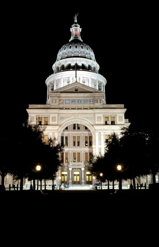 the lights shine brightly on the building's dome at night