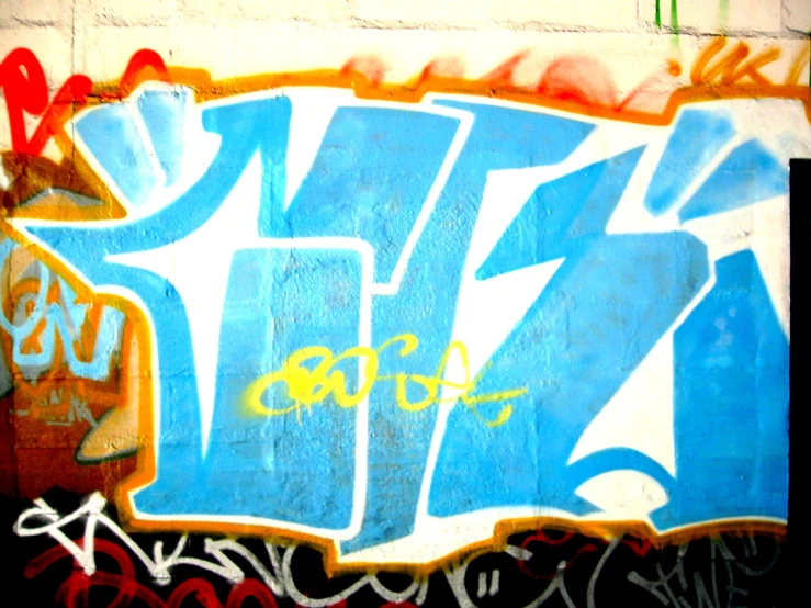 a blue and white wall covered with graffiti
