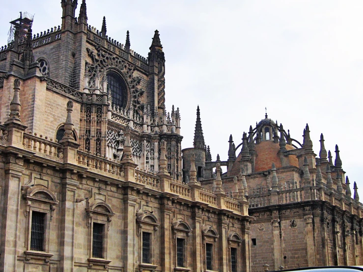 a stone building with a tall tower next to a parked car