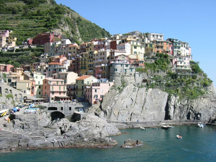 several people stand on boats in the water in front of some buildings