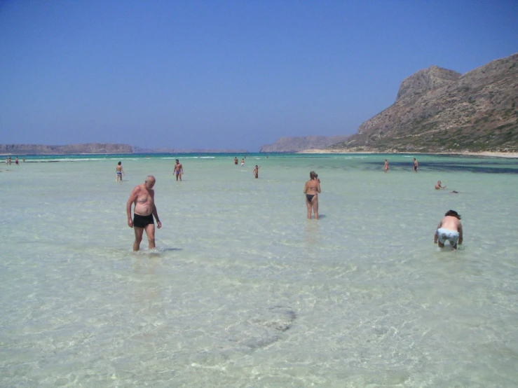 many people are walking in the clear water