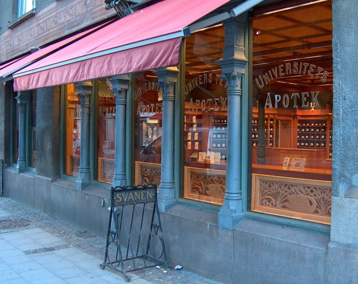 the view from the street of an outside bar with pink awnings