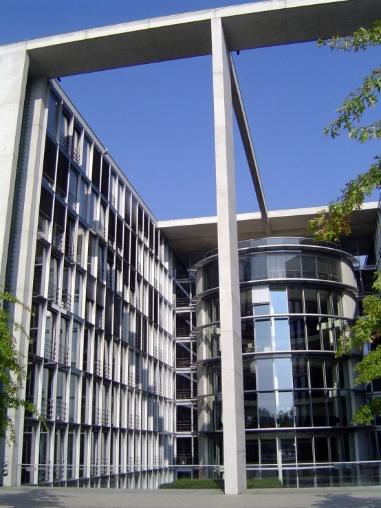 two metal structures in front of a building on a sunny day