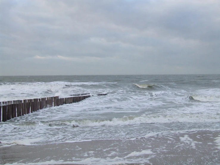 waves roll into the shore on a cloudy day