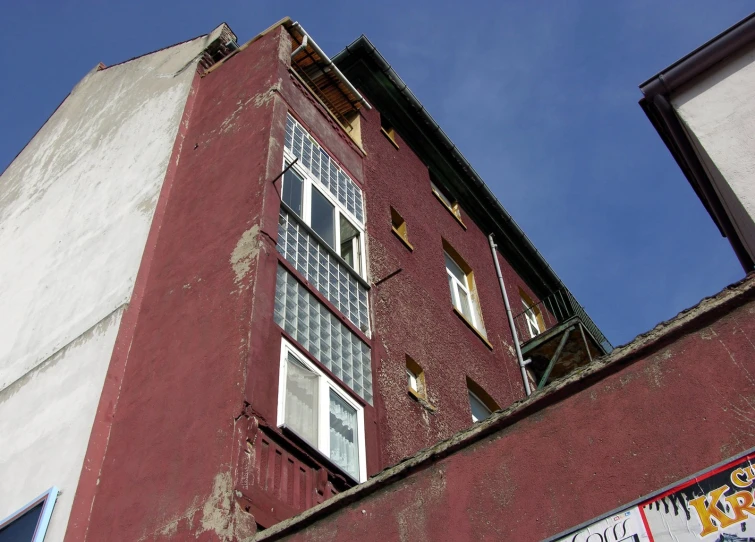 a tall brick building with white windows sitting below a blue sky