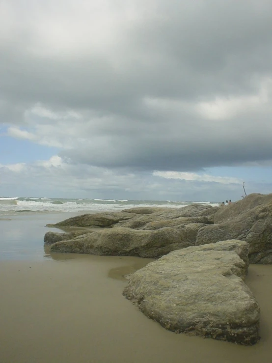 several rocks sitting on top of a sandy beach