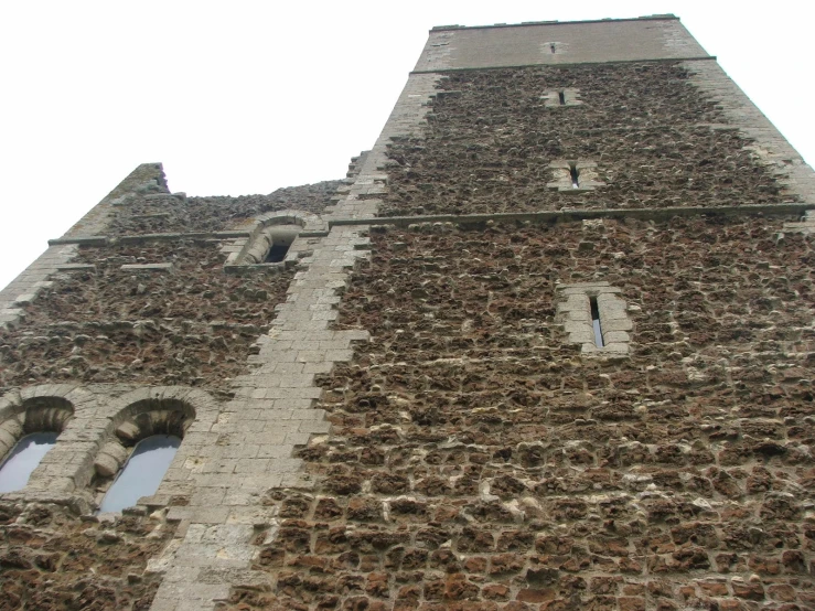 two windows are pictured in the side of this stone building