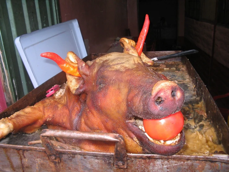 a fake cow with its mouth open is sitting in a container