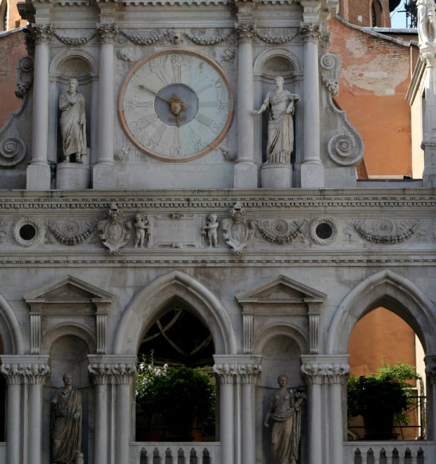 a fancy building with statues, clocks and archways