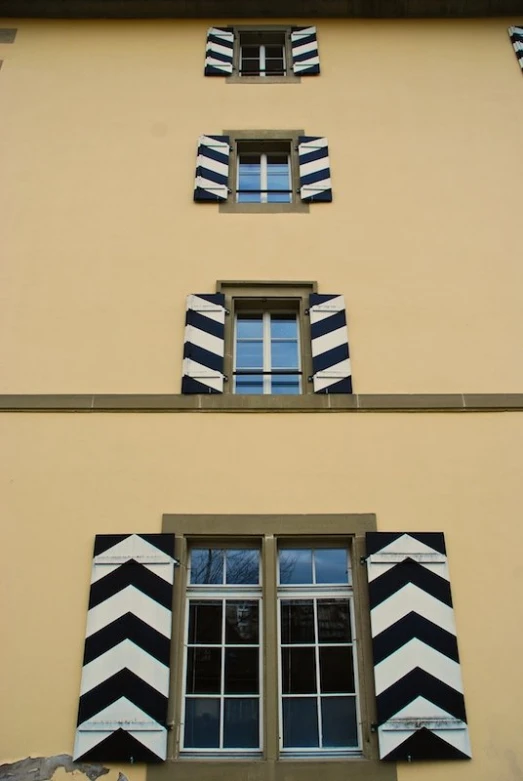 black and white striped curtains hanging from the side of an apartment building