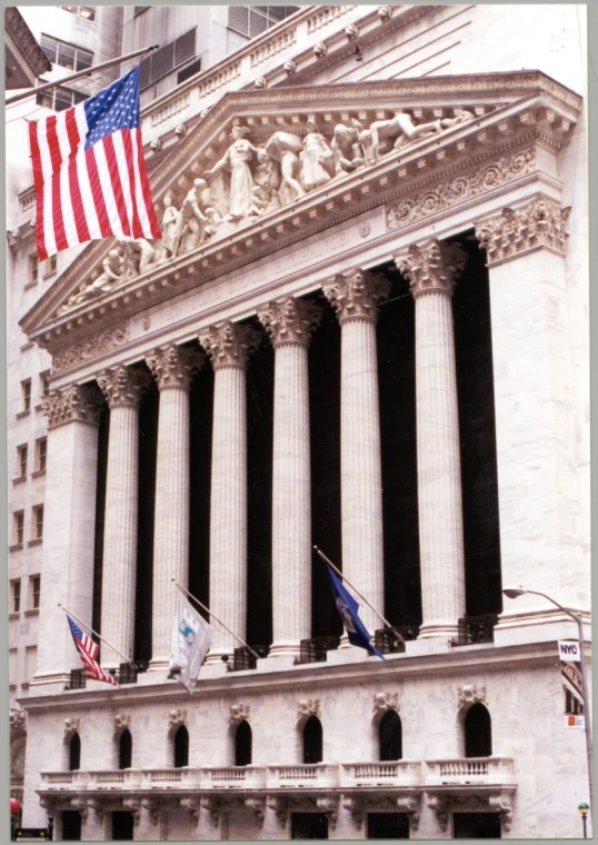 a large building with columns and flags flying from it