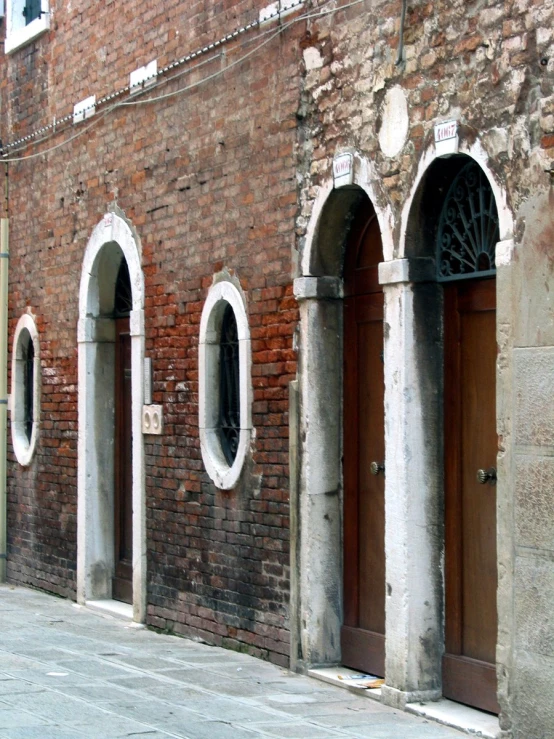 a red brick wall with arched windows and a fire hydrant