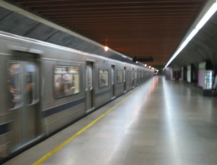 a train traveling past a loading platform in a train station