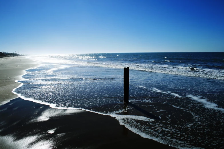 water and sand with the sun in the background