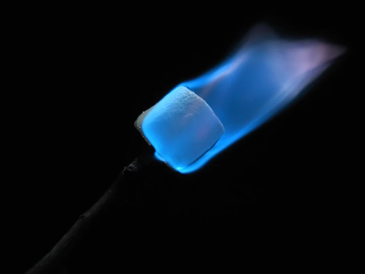 this is the side of a stove burner with blue flame