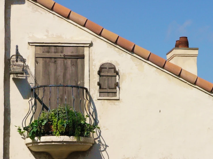 a balcony with a chair that has flowers in the planter